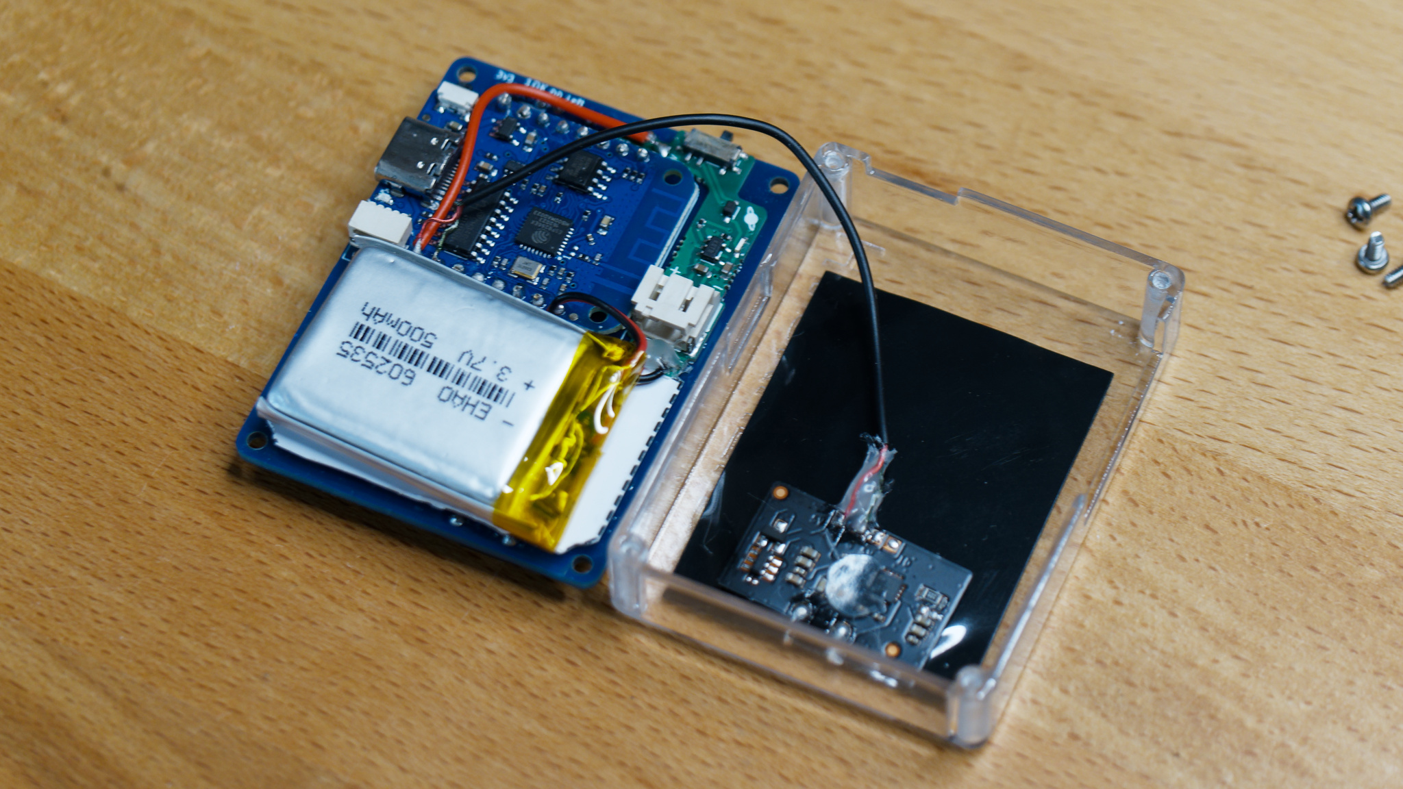 Back side of HackHeld with case next to it. Wireless charging module inside of case.